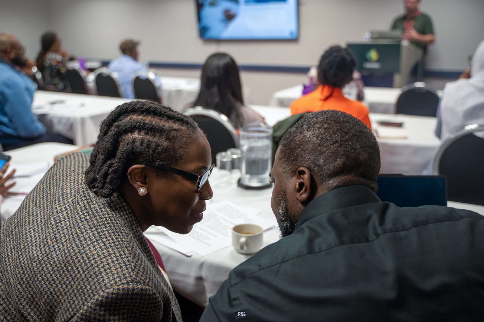Regina participants seated at tables, taking part in a business-development session