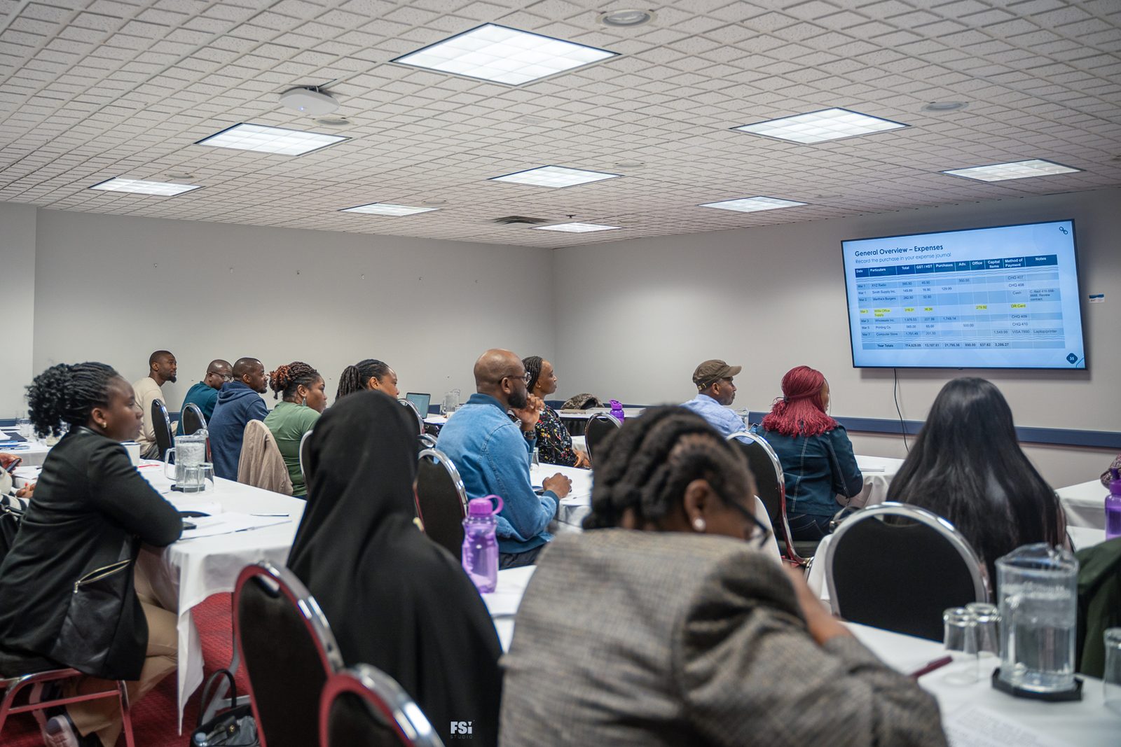A wide view of the Regina training room with entrepreneurs at their tables