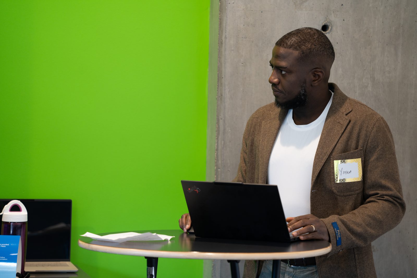 A facilitator presents from a laptop at the front of the Saskatoon room