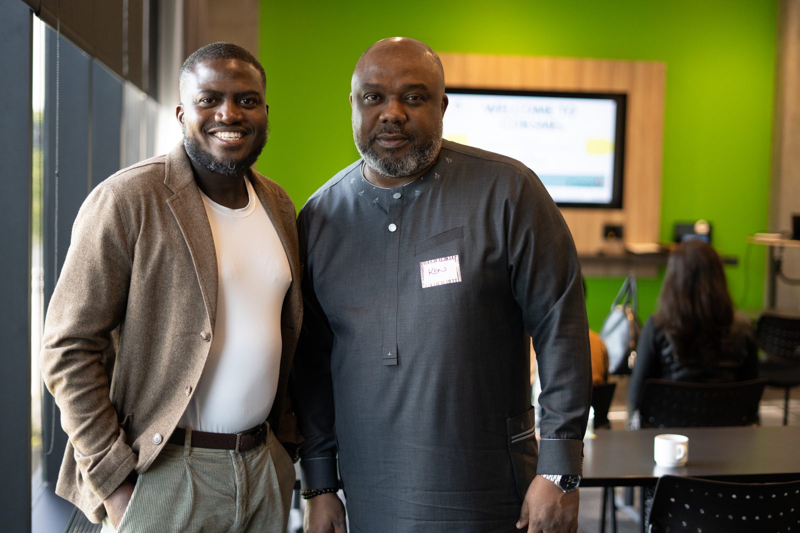 Two participants stand together and smile during a networking moment in Saskatoon